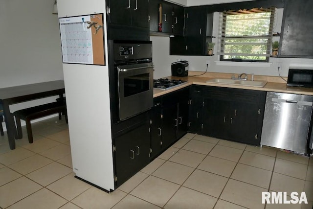 kitchen featuring light tile patterned floors, black appliances, and sink