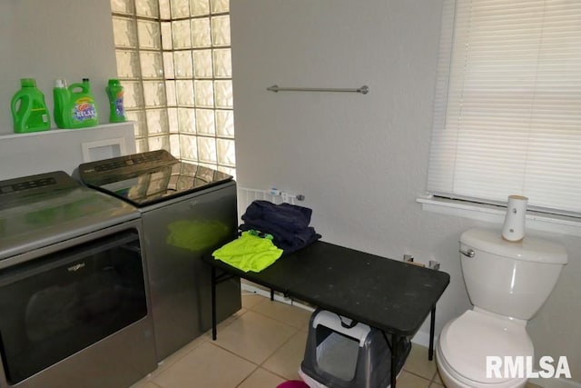 clothes washing area featuring washing machine and clothes dryer and light tile patterned floors