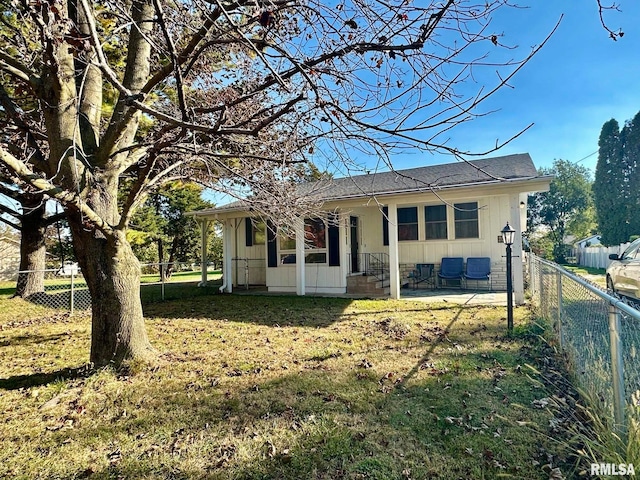 back of house with a patio area and a lawn