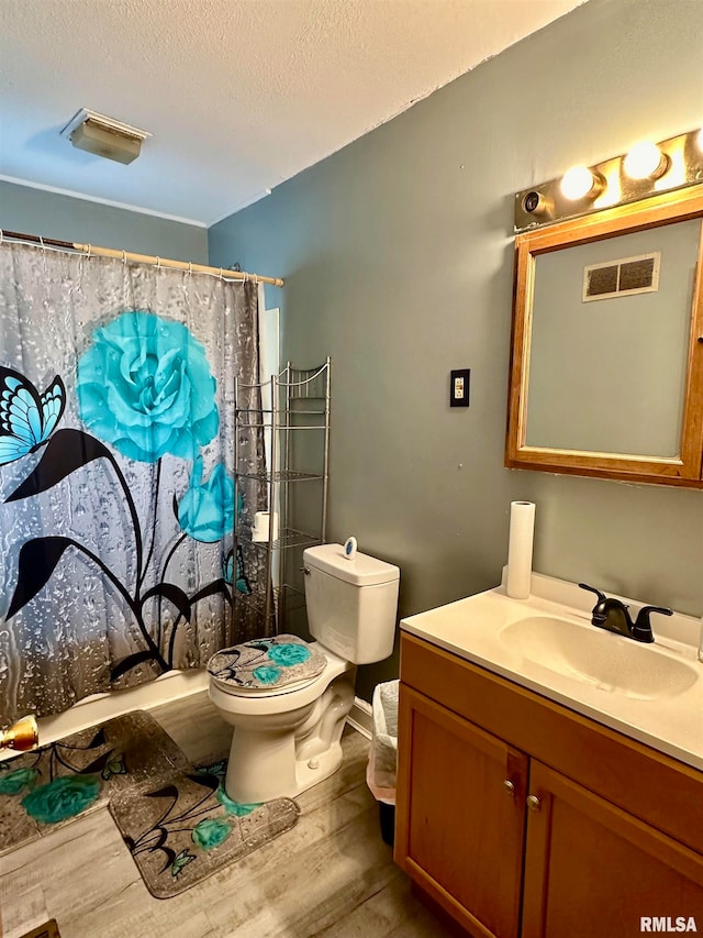 full bathroom with toilet, shower / bath combo with shower curtain, hardwood / wood-style floors, vanity, and a textured ceiling