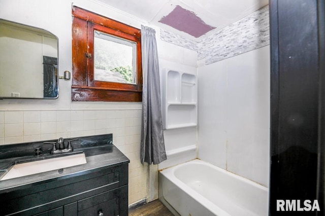 bathroom with tasteful backsplash, hardwood / wood-style flooring, independent shower and bath, tile walls, and vanity