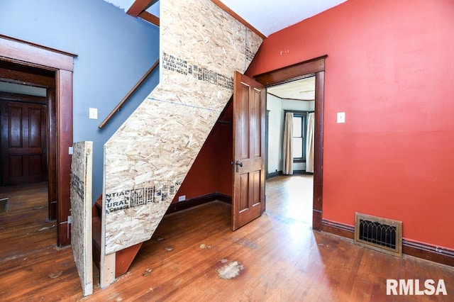 hallway with vaulted ceiling and dark hardwood / wood-style floors