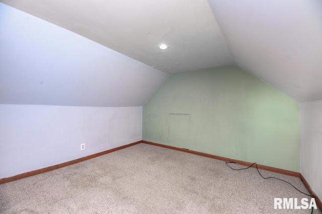 additional living space with carpet flooring and lofted ceiling