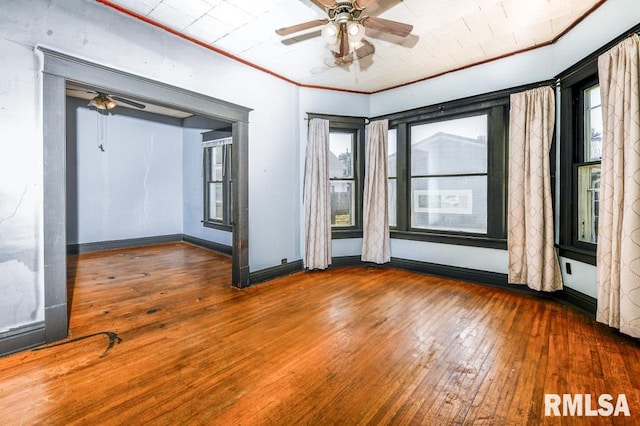 empty room with ceiling fan, wood-type flooring, and ornamental molding