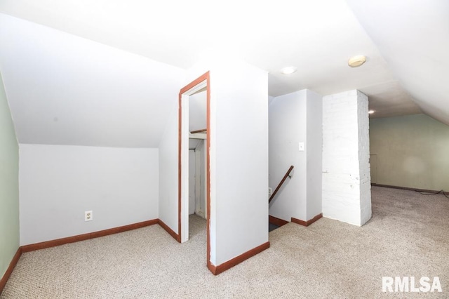 bonus room featuring light carpet and vaulted ceiling