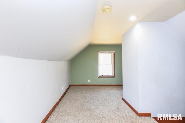 additional living space with vaulted ceiling and light colored carpet