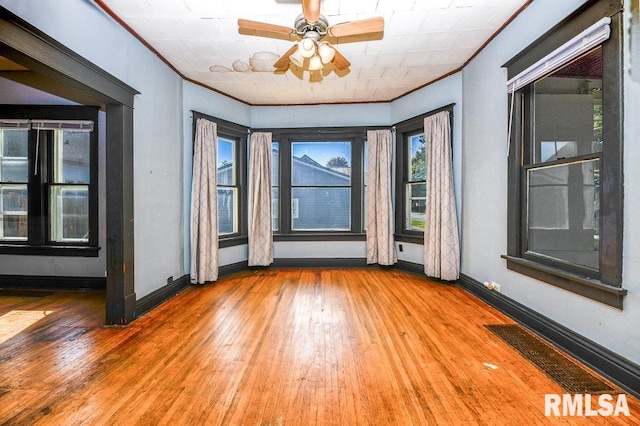 interior space with ornamental molding, hardwood / wood-style floors, and ceiling fan