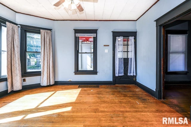 empty room with ornamental molding, dark hardwood / wood-style floors, and ceiling fan