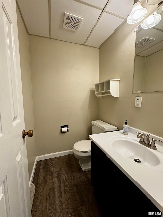 bathroom with toilet, hardwood / wood-style flooring, and vanity