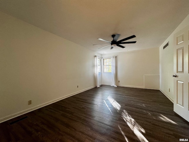 empty room with ceiling fan and dark hardwood / wood-style flooring