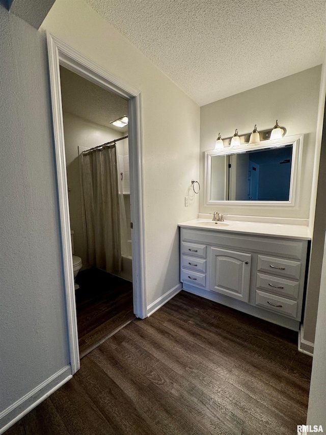 full bathroom with toilet, shower / bath combo with shower curtain, wood-type flooring, vanity, and a textured ceiling