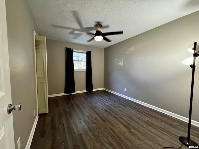 unfurnished bedroom with dark hardwood / wood-style floors, a textured ceiling, and ceiling fan