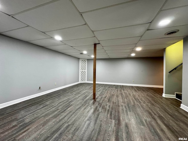 basement featuring dark wood-type flooring and a drop ceiling