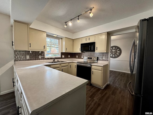 kitchen with appliances with stainless steel finishes, dark hardwood / wood-style flooring, sink, and cream cabinetry