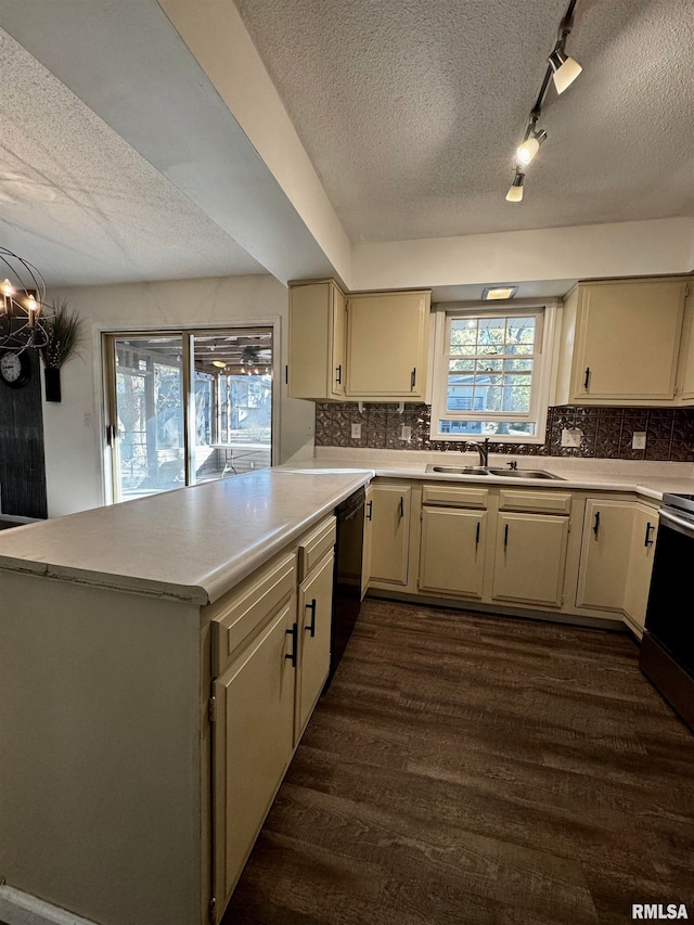 kitchen with black dishwasher, sink, dark hardwood / wood-style flooring, kitchen peninsula, and decorative backsplash