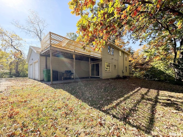 rear view of house with a lawn and a garage