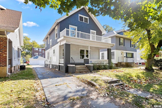 view of property with cooling unit, a garage, a porch, an outdoor structure, and a balcony