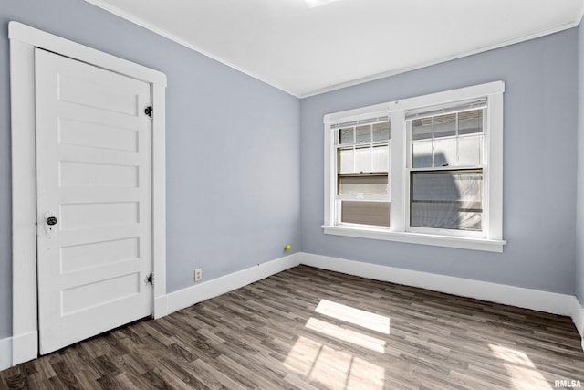 empty room featuring crown molding and hardwood / wood-style flooring