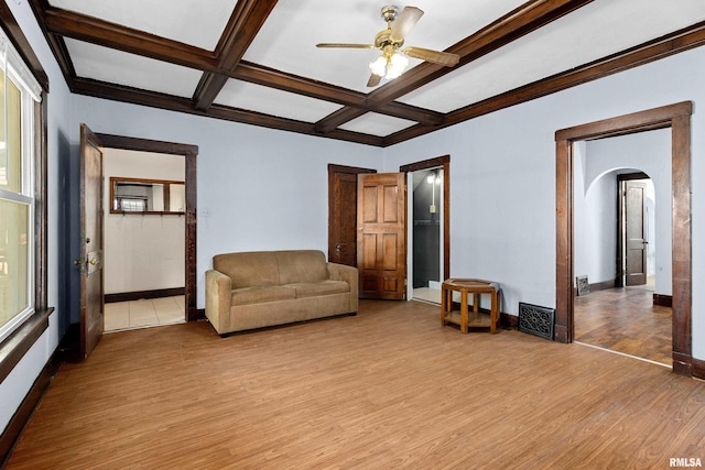 living room featuring ceiling fan, coffered ceiling, beamed ceiling, and light wood-type flooring