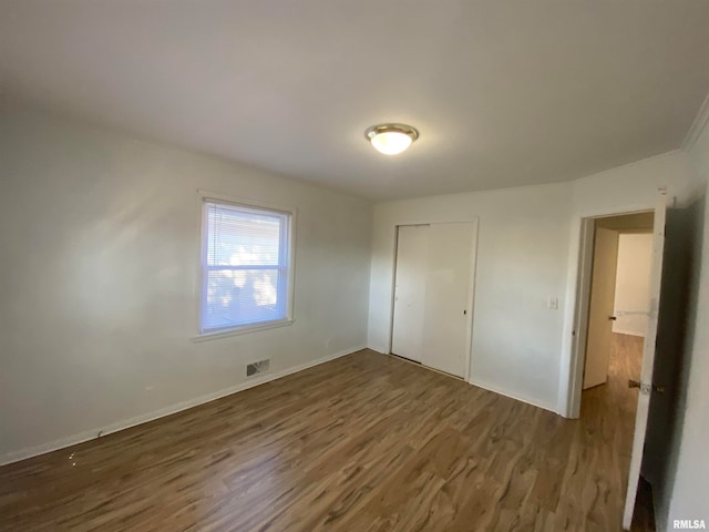 unfurnished bedroom with a closet and dark wood-type flooring