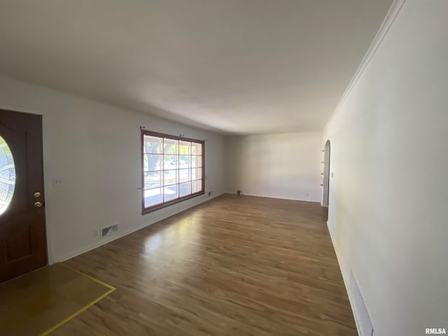 foyer entrance with ornamental molding and dark hardwood / wood-style floors