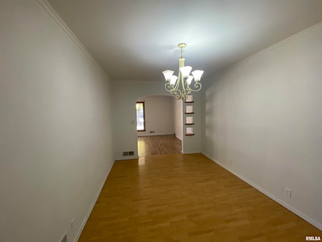 interior space with crown molding, hardwood / wood-style flooring, and a chandelier