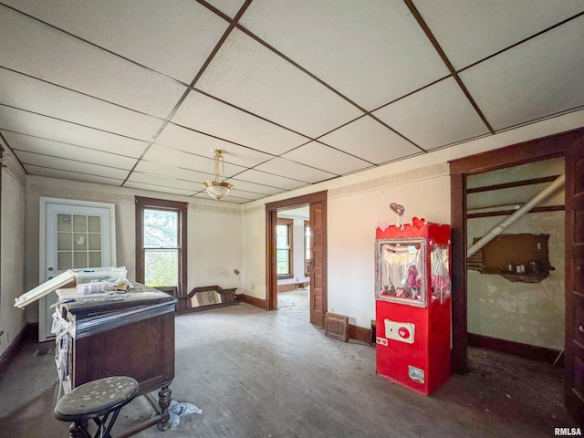 miscellaneous room featuring a drop ceiling and concrete flooring