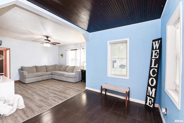 living room featuring dark wood-type flooring and ceiling fan