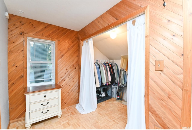 walk in closet featuring light parquet flooring and vaulted ceiling