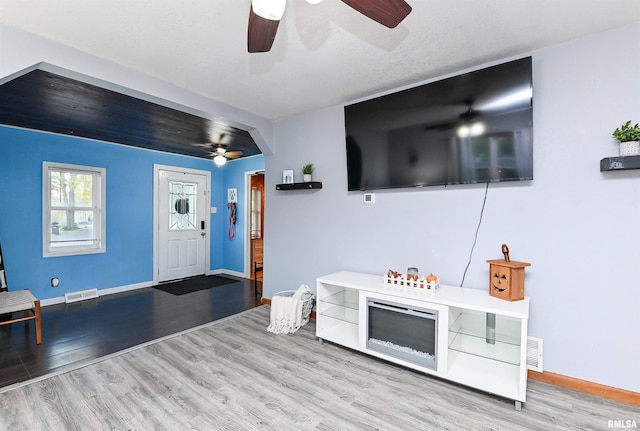 living room with light hardwood / wood-style flooring and ceiling fan