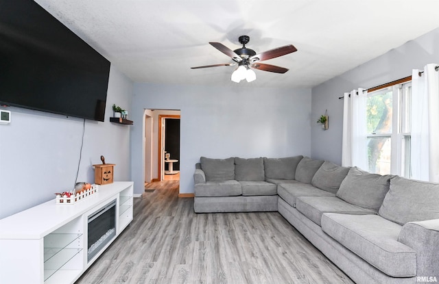 living room with light hardwood / wood-style floors and ceiling fan