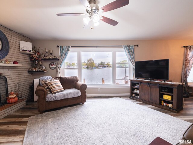 living room featuring a brick fireplace, ceiling fan, and dark hardwood / wood-style flooring