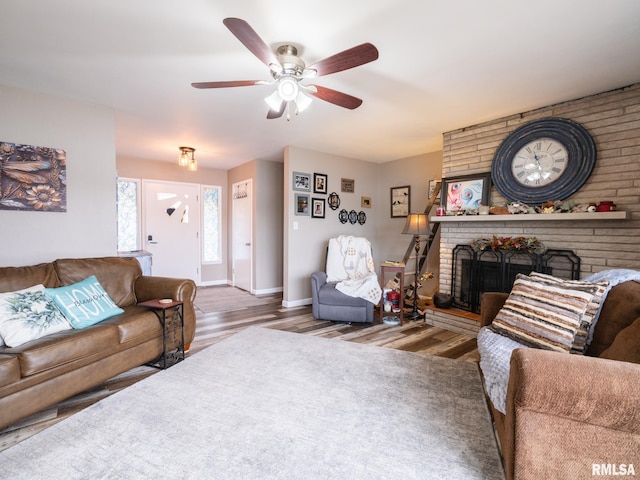 living room featuring ceiling fan, a fireplace, and hardwood / wood-style flooring