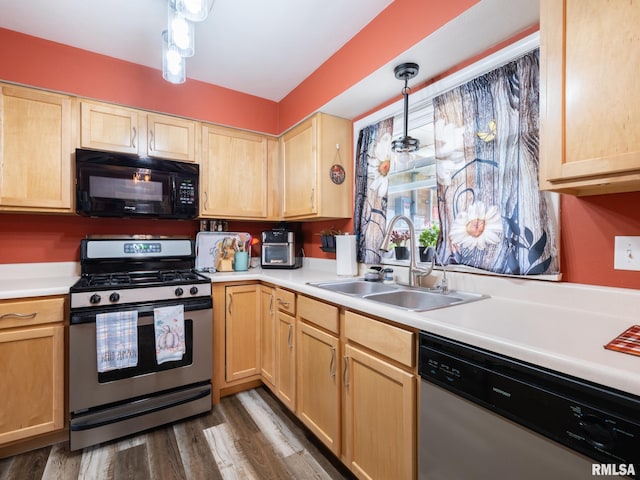 kitchen with dark hardwood / wood-style flooring, appliances with stainless steel finishes, light brown cabinetry, sink, and decorative light fixtures