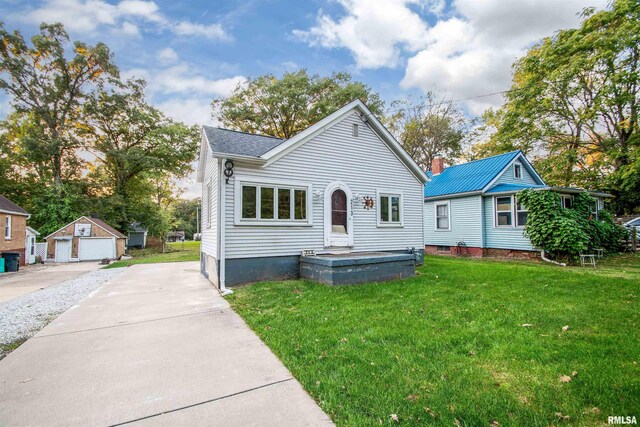 bungalow-style house featuring a front yard, an outbuilding, and a garage