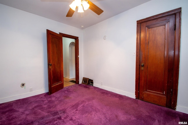 carpeted spare room featuring ceiling fan