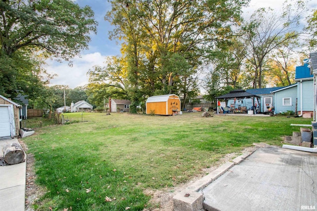 view of yard with a gazebo, a storage shed, and a patio