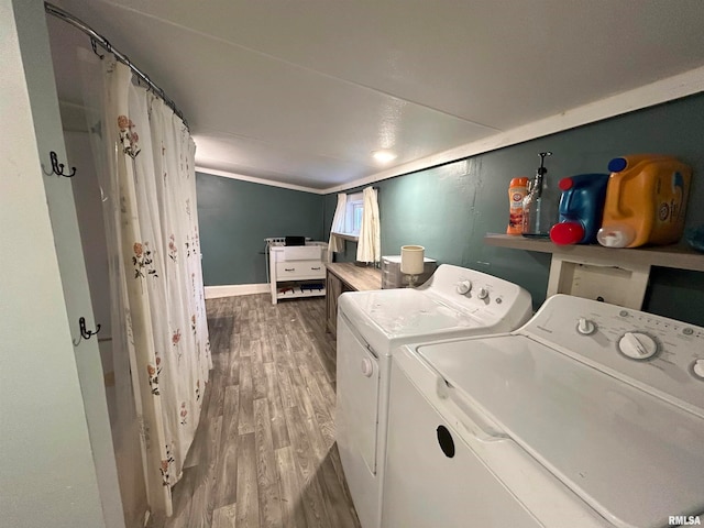 clothes washing area featuring hardwood / wood-style flooring and separate washer and dryer