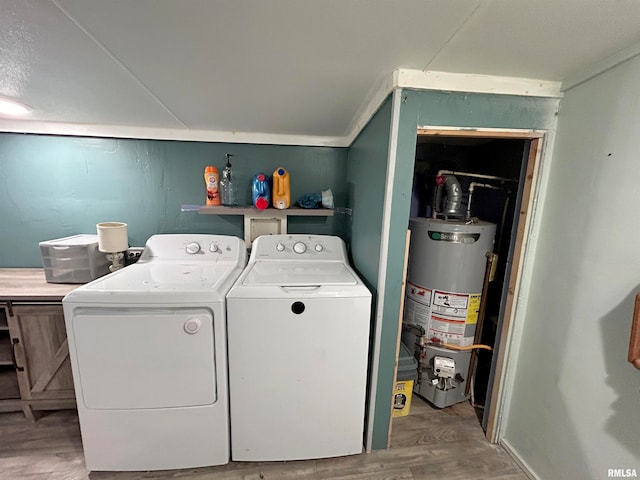 washroom featuring hardwood / wood-style floors, water heater, and washing machine and clothes dryer