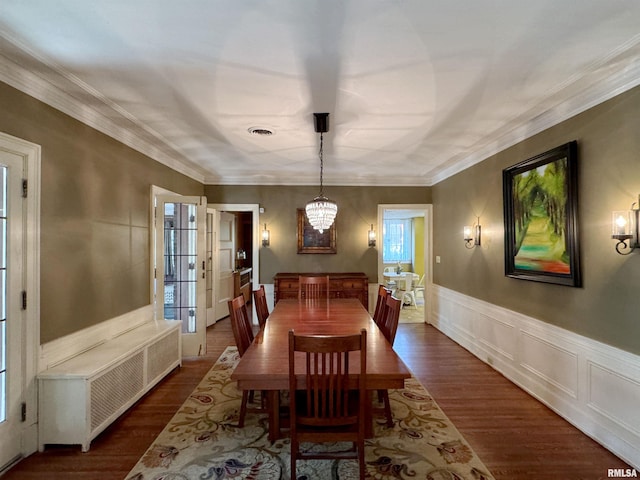 dining room with a notable chandelier, ornamental molding, and dark hardwood / wood-style flooring