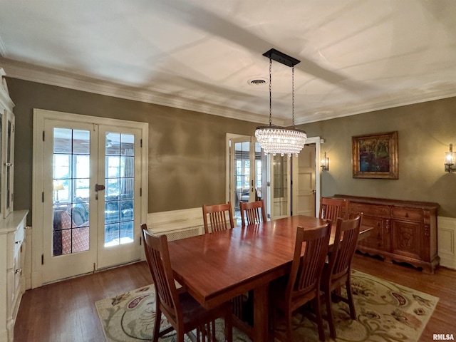 dining area featuring an inviting chandelier, french doors, ornamental molding, and hardwood / wood-style flooring