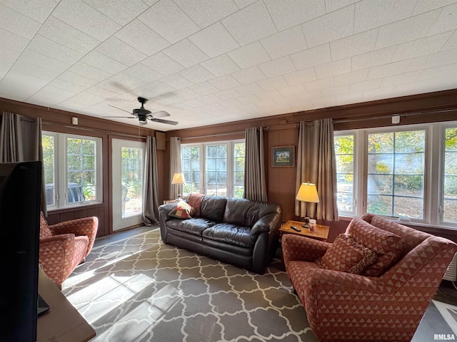 living room featuring wooden walls and ceiling fan