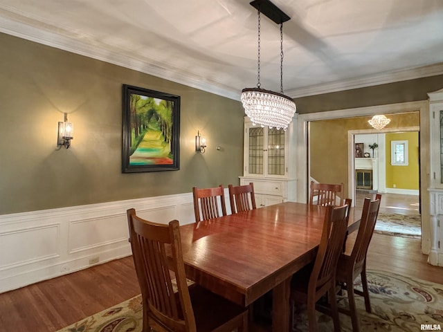 dining room featuring crown molding, hardwood / wood-style floors, and a chandelier