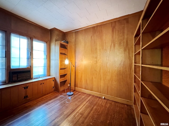 spare room featuring wooden walls, cooling unit, and wood-type flooring