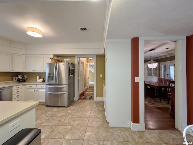 kitchen featuring appliances with stainless steel finishes, white cabinetry, light wood-type flooring, pendant lighting, and crown molding