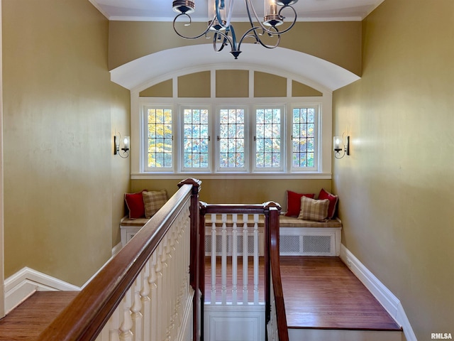 stairway featuring ornamental molding, hardwood / wood-style floors, and a notable chandelier