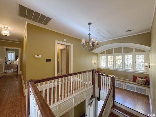 hall featuring ornamental molding, a chandelier, and dark hardwood / wood-style floors