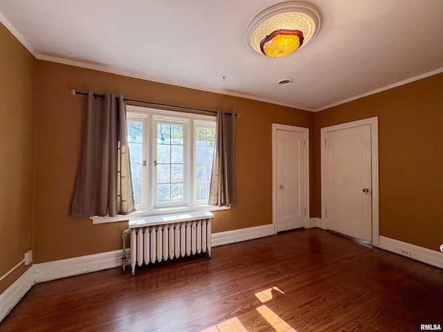 unfurnished room featuring crown molding, dark hardwood / wood-style floors, and radiator