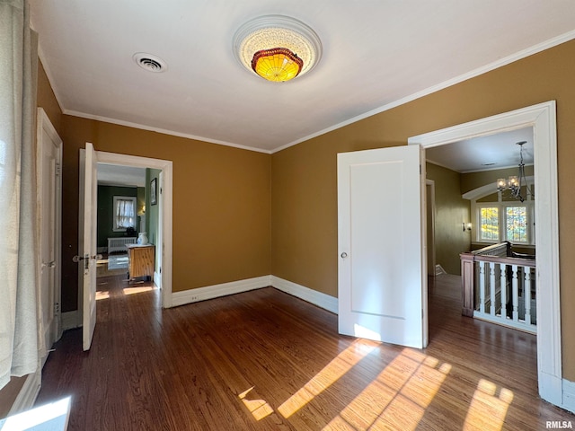 unfurnished room with crown molding, hardwood / wood-style flooring, and a chandelier