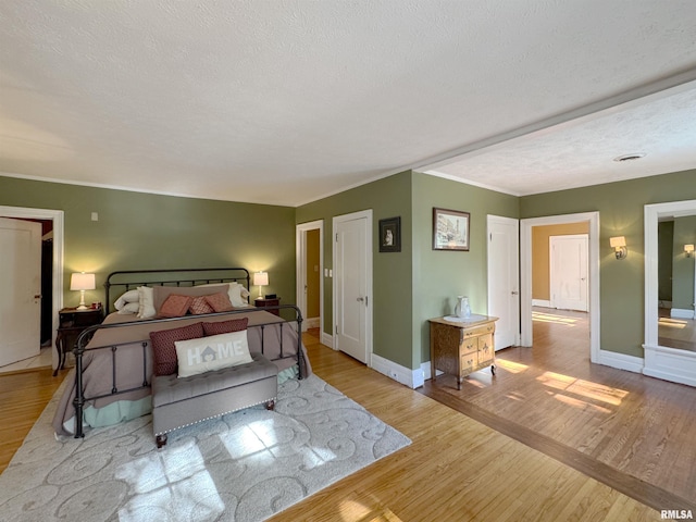 bedroom with a textured ceiling and light wood-type flooring